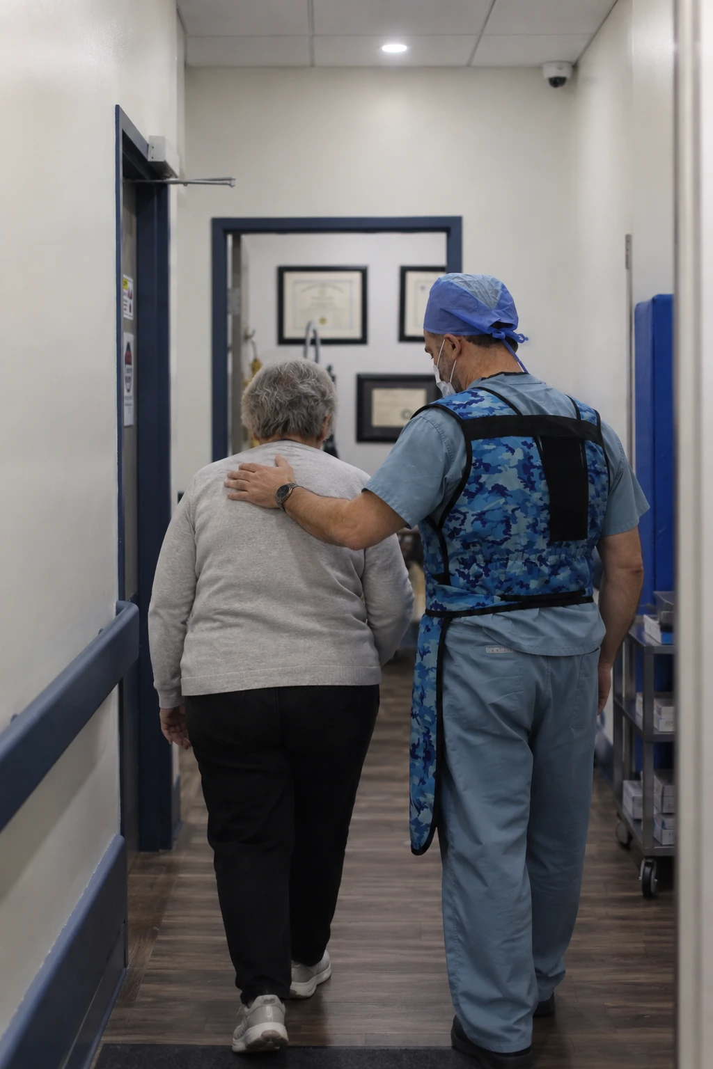 Dr. Elbaridi walking a patient down the clinic hallway, his hand on her shoulder