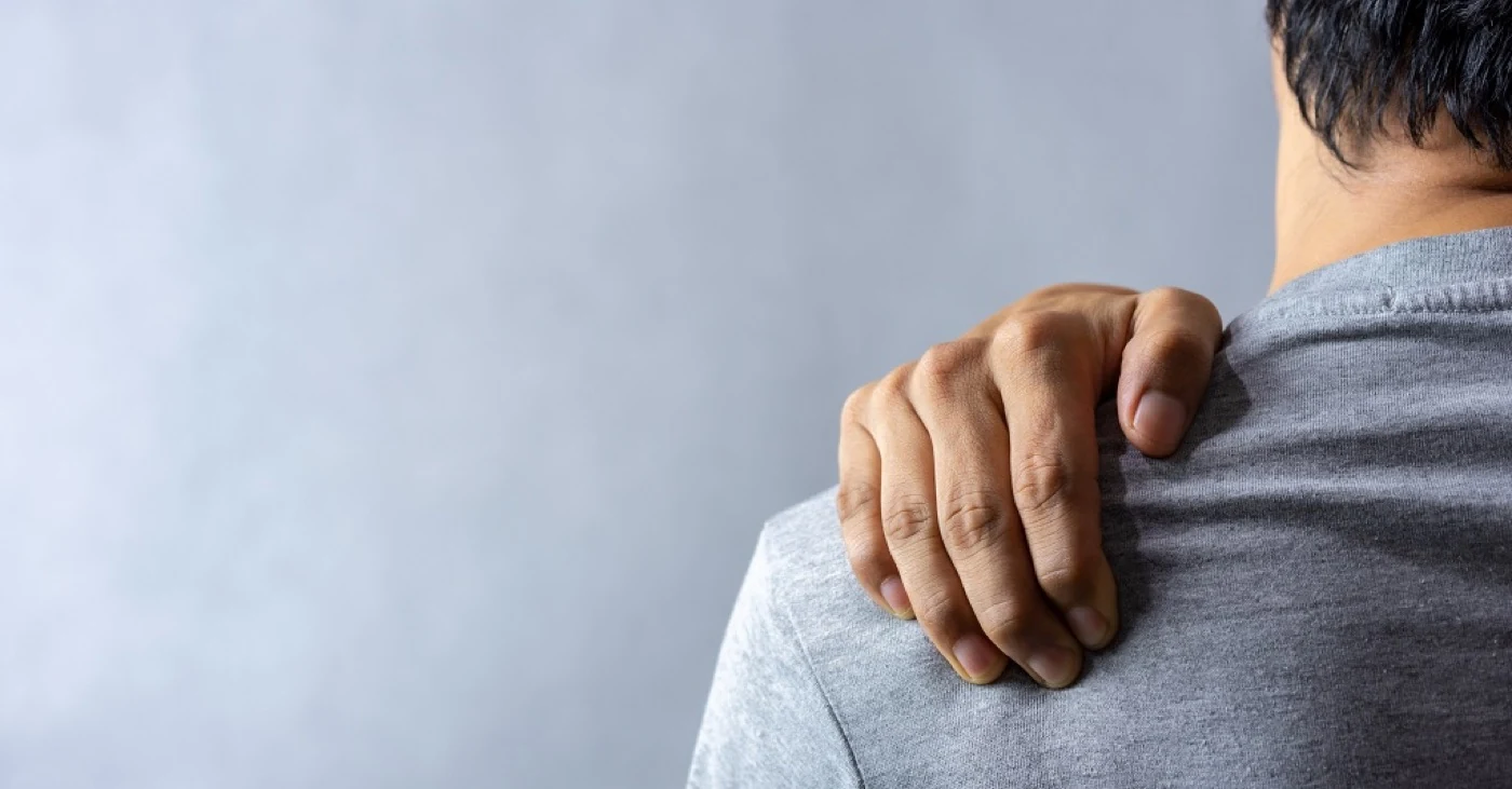 Person holding a painful shoulder