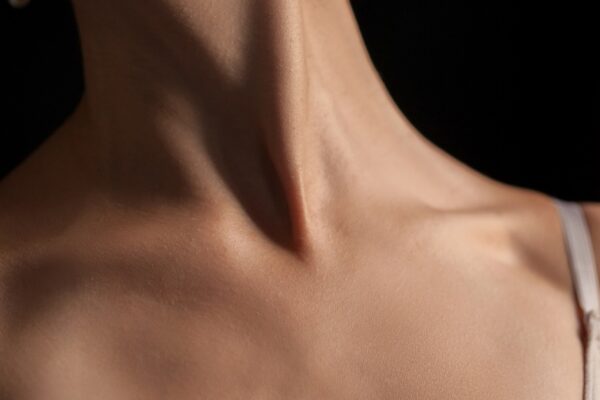 The close-up of a young woman's neck on dark background
